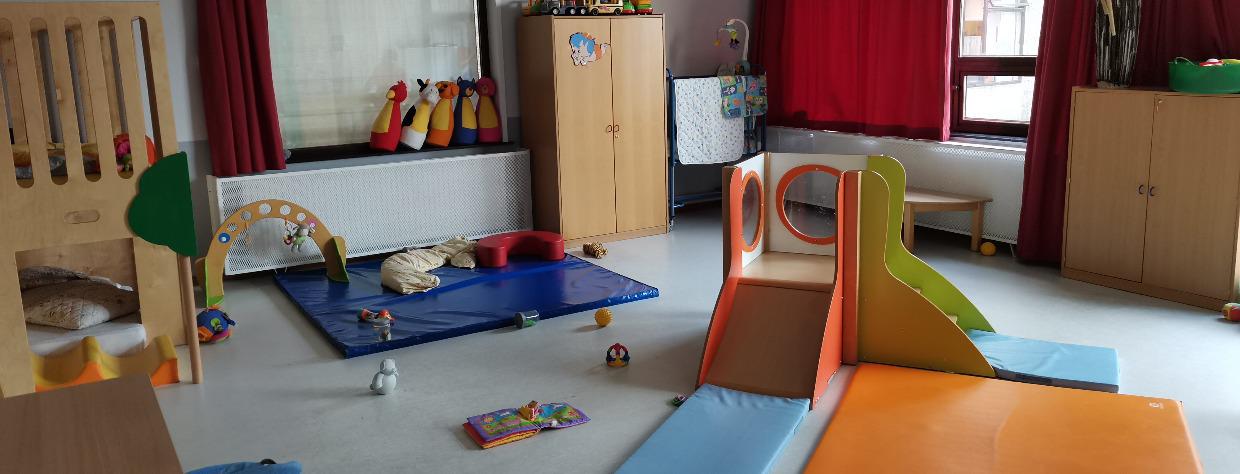 Deux tobogans à l'intérieurs avec des tapis et quelques jouets