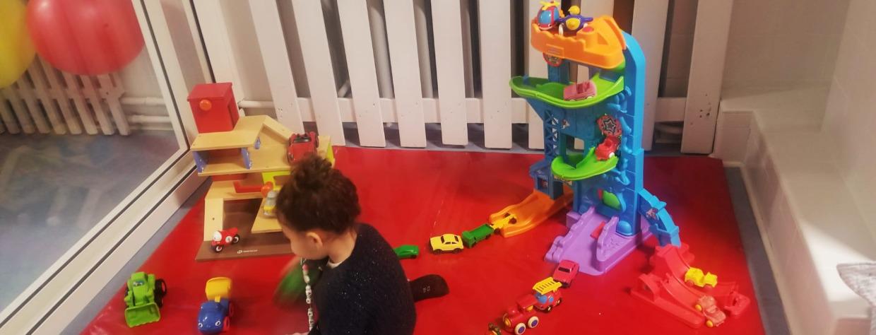 Enfant qui joue sur un tapis avec des jouets