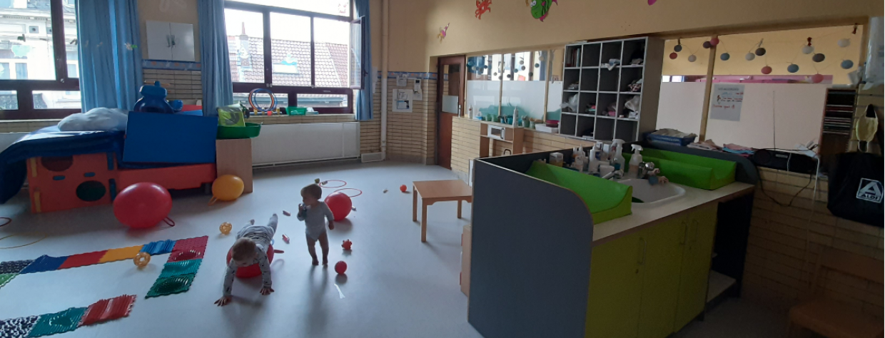 Coin pour le change avec évier  + deux enfants qui jouent avec des ballons sauteurs