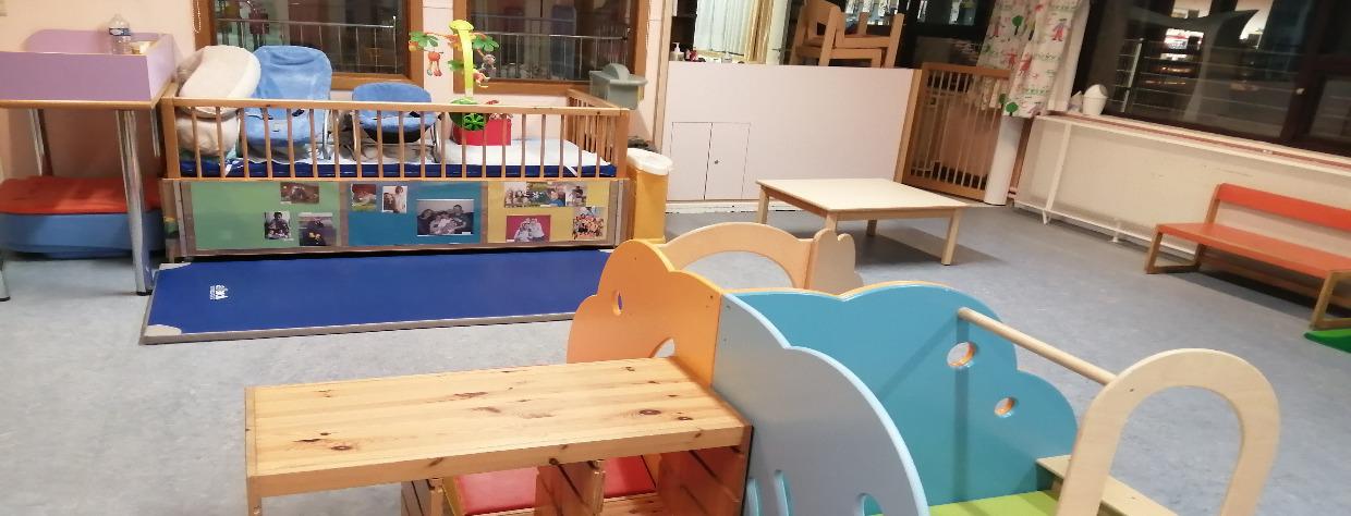 Salle avec les modules de jeu en bois, un banc et une table