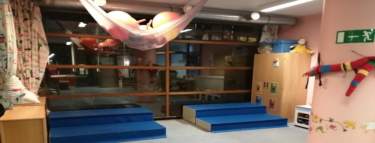 Salle avec des blocs en mousse, hamacs au plafond pour ranger les ballons sauteurs