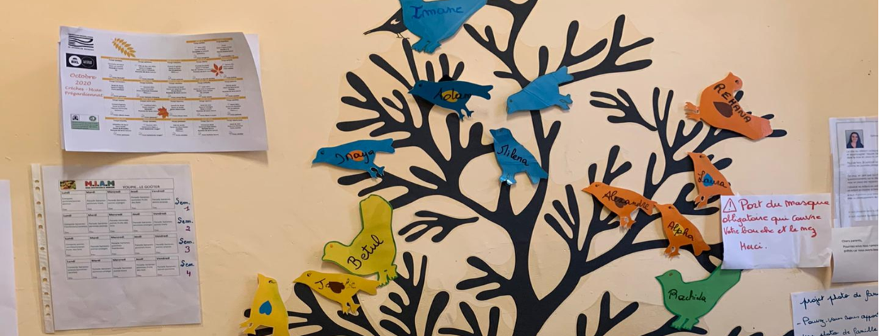 Arbre où des oiseaux en papier sont accrochés aux branches. Sur ces oiseaux il y a le nom des enfants