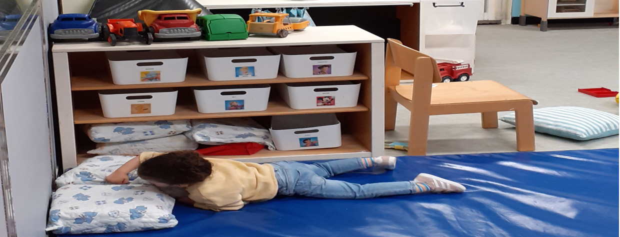 Enfat couché sur un tapis qui joue avec des oreillers