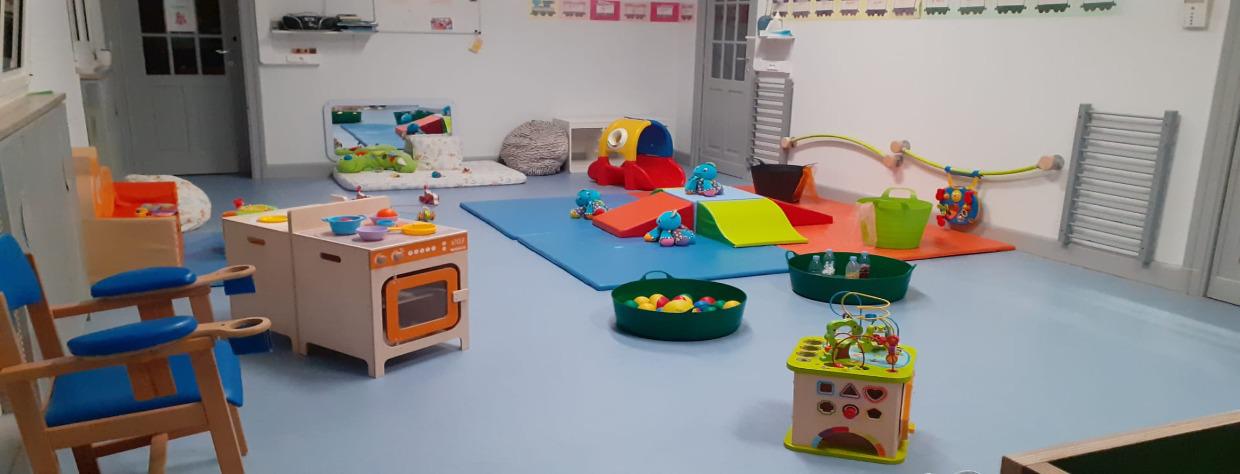 Espace de jeu avec une cuisine miniature, des tapis et blocs en mousse