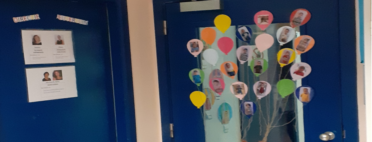 Porte bleue avec des dessins de ballons dans lesquels il y  ales photos des enfants