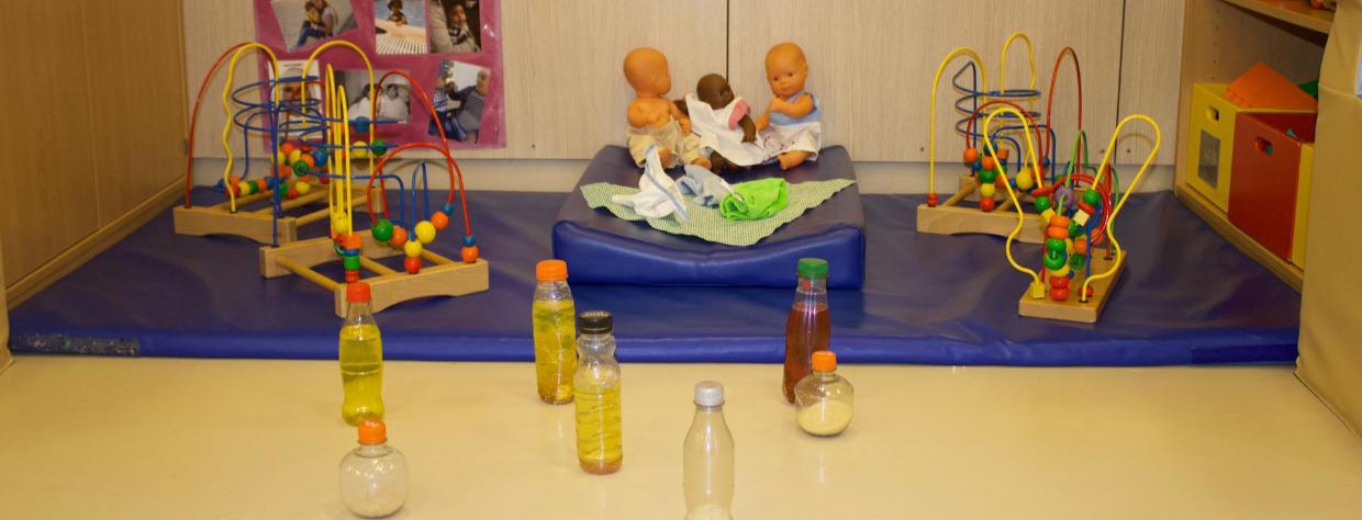 Différents labyrinthe en bois, tapis, poupées et bouteilles en plastique remplies de boissons