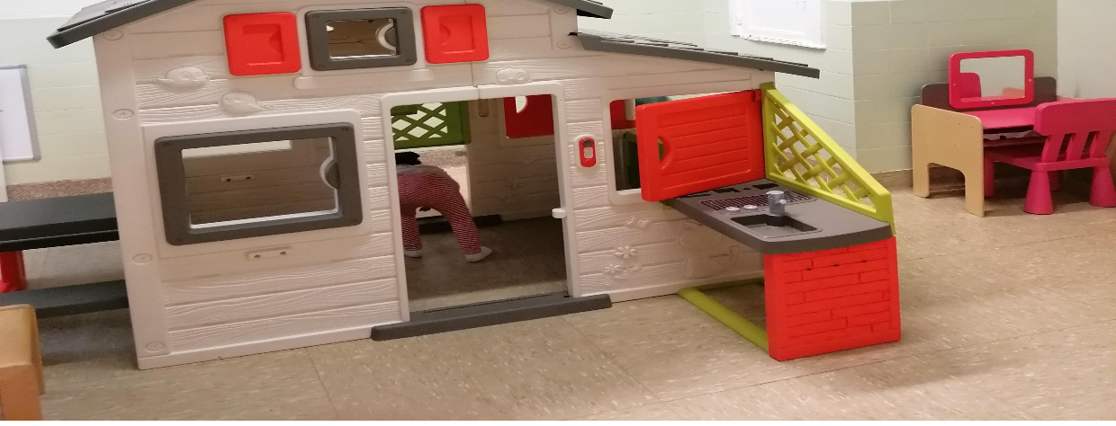 Enfant qui joue dans une petite maison en plastique à l'intérieur